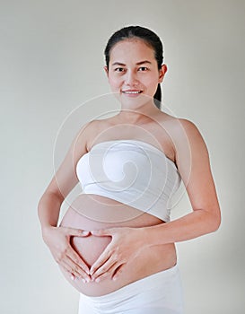 Pregnant Woman hands in a heart shape on her belly