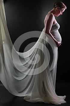 Pregnant woman with hands on her belly stroking her baby stock photo