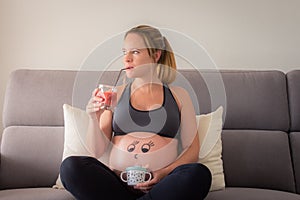 Pregnant Woman with a happy face drawn on the belly