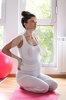 Pregnant woman having back pain while exercising