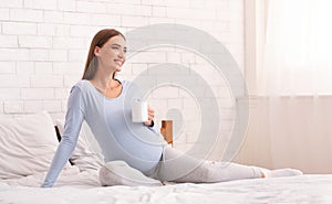 Pregnant Woman Having Coffee Holding Cup Sitting On Bed
