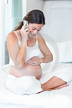 Pregnant woman having conversation on cellphone