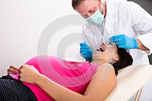 Pregnant Woman Having Teeth Examined At Dentists