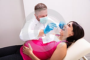 Pregnant Woman Having Teeth Examined At Dentists