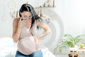 Pregnant woman having toxicosis in bedroom photo