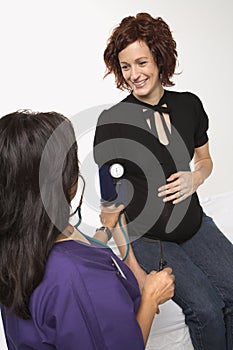 Pregnant woman having vitals checked.