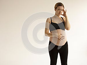 Pregnant woman with a headache and pain. Young pregnant woman with headache and backache copy space. Pregnancy
