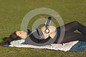 Pregnant woman with headphones over her belly