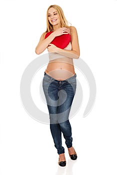 Pregnant woman with a heart pillow