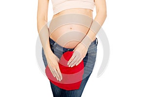 Pregnant woman with a heart pillow