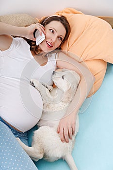 Pregnant woman with her dog at home