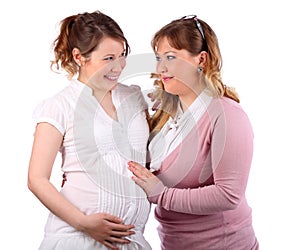 Pregnant woman and her girlfriend touching her stomach