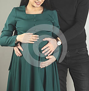 pregnant woman and her handsome husband hugging belly