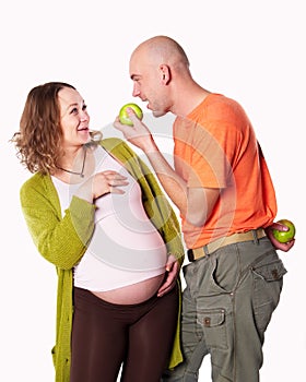 The pregnant woman with her husband and green apple