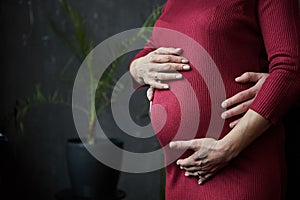 Pregnant woman and her husband hugging on the tummy together