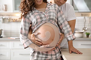 Pregnant woman with her husband in kitchen