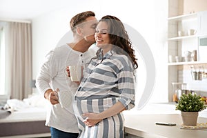Pregnant woman with her husband in kitchen