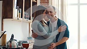 Pregnant woman and her husband in kitchen at home