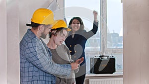 A pregnant woman with her husband looking at the keys from new apartment - a real estate agent jumping and smiling