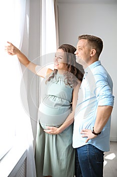 Pregnant woman with her husband looking out