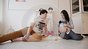 Pregnant woman and her husband and newborn clothing