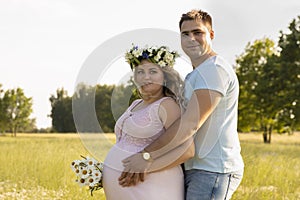 A pregnant woman with her husband is resting in nature