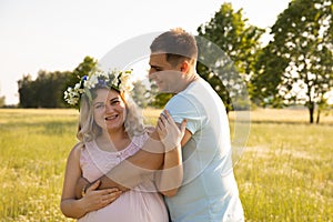 A pregnant woman with her husband is resting in nature