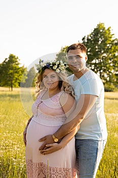 A pregnant woman with her husband is resting in nature