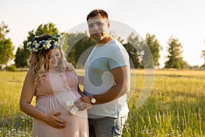 A pregnant woman with her husband is resting in nature