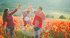 Pregnant woman her husband and their daughter in poppy field