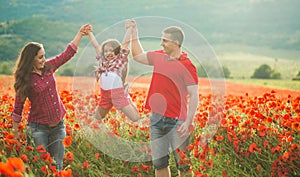 Pregnant woman her husband and their daughter in poppy field