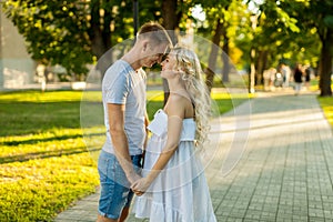 Pregnant woman with her husband walking in a park