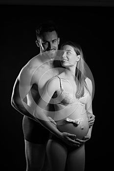 Pregnant woman and her man studio black and white photography