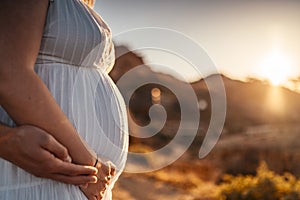 Pregnant woman with her partner holding her belly