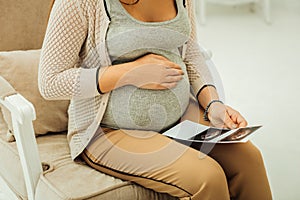 Pregnant woman with her printed ultrasound results