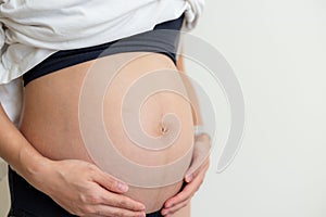 Pregnant woman hold belly close up