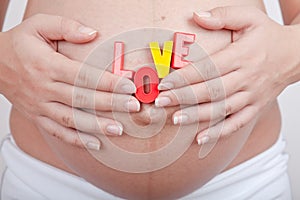 Pregnant woman hold in hand word girl