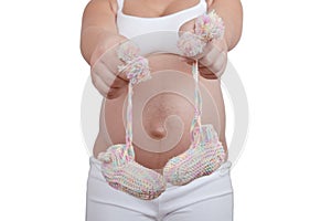 Pregnant woman hold in hands baby shoes