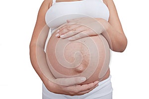 Pregnant woman hold hands on a belly