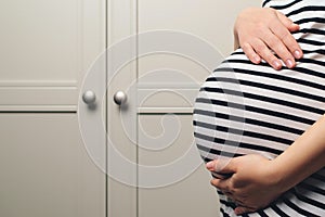 Pregnant woman holdig hands on belly, closeup. Pregnant woman's belly. Baby expectation