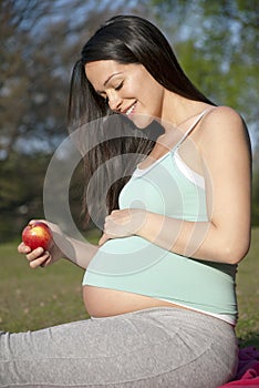 Pregnant woman holding apple