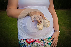 Pregnant woman holding babies shoes