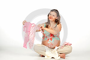 Pregnant woman holding baby bodysuit