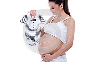 Pregnant woman holding baby clothes