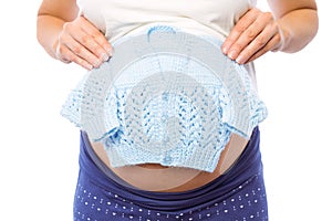 Pregnant woman holding baby clothes