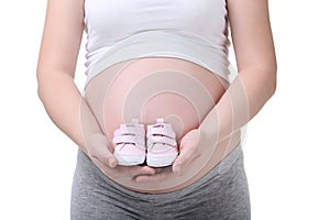 Pregnant woman holding baby shoes