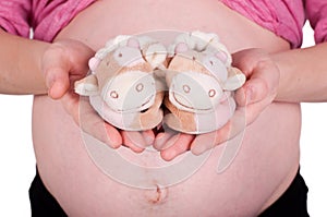 Pregnant woman holding baby shoes