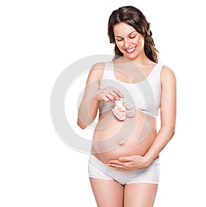 Pregnant woman holding baby shoes