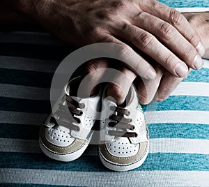 Pregnant Woman Holding Baby Shoes on her Belly