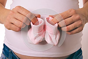 Pregnant Woman Holding Baby Socks